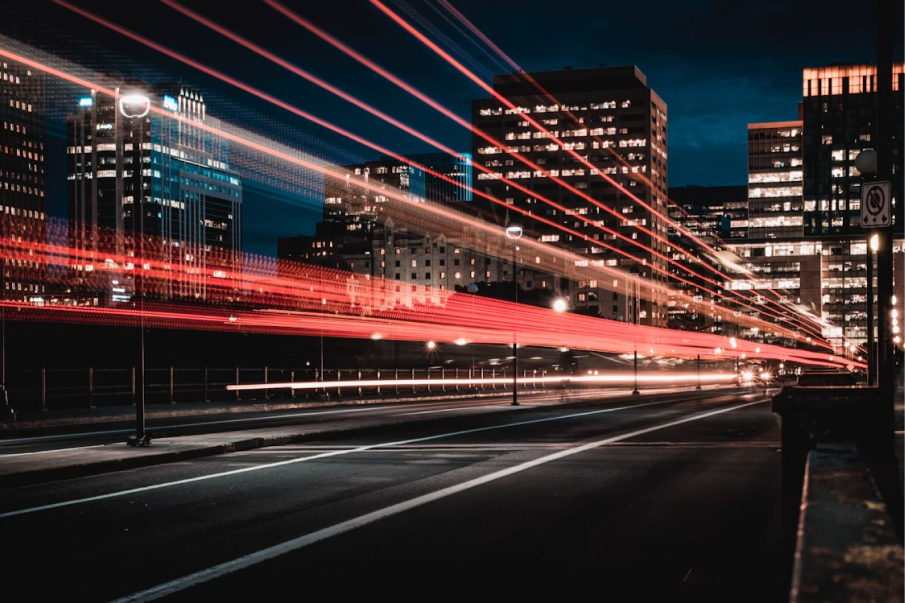 City traffic light trails at night under high-rise buildings